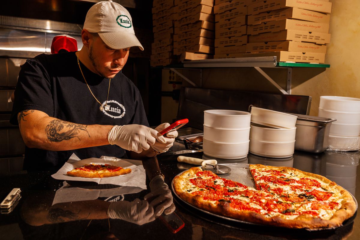 Pizza owner taking photos.